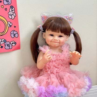 Bambola Reborn Raya da 55 cm con capelli lunghi e abito rosa