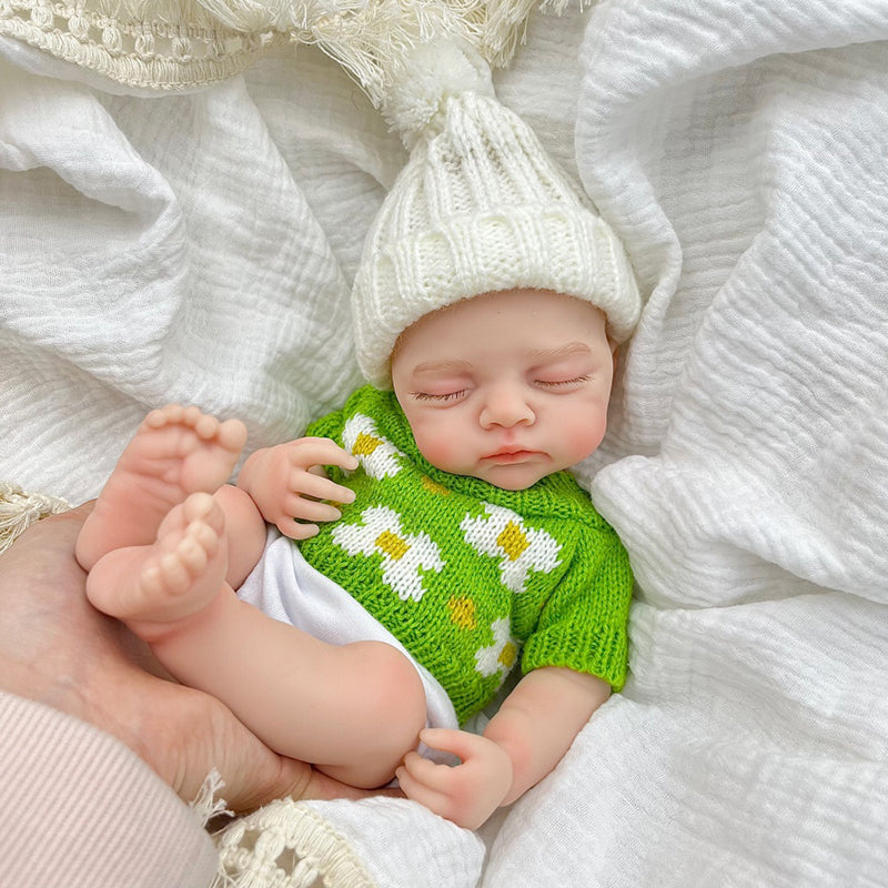 Bambola reborn Irys 30 cm realistica interamente in silicone con occhi chiusi vestita con un maglione verde