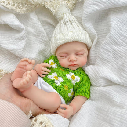 Bambola reborn Irys 30 cm realistica interamente in silicone con occhi chiusi vestita con un maglione verde