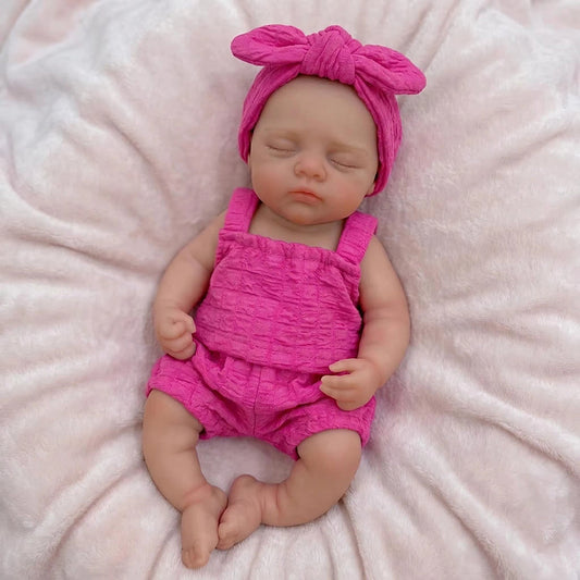 Bambola reborn Irys 30 cm realistica interamente in silicone con occhi chiusi vestita con abiti rosa