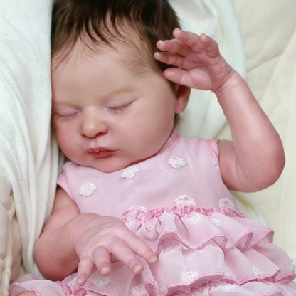 Bambina reborn Laura 50 cm realistica con occhi chiusi e capelli corti vestita di rosa