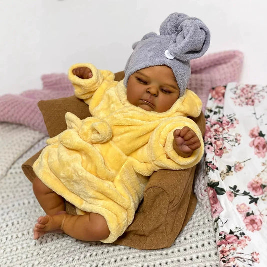 Bambola reborn realistica da 19 pollici con occhi chiusi e pelle scura Peaches in accappatoio giallo