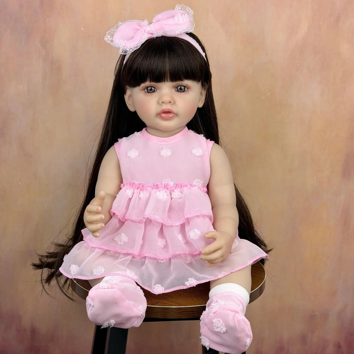 Bambola reborn Betty 55 cm con capelli lunghi e vestito rosa