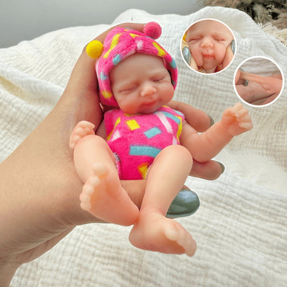 Bambola reborn Pascale Mini in silicone da 15 cm con occhi chiusi vestita con abiti rosa