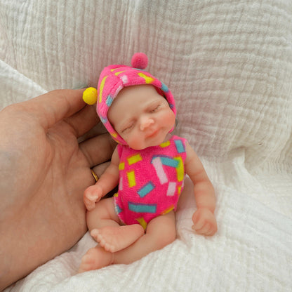 Bambola reborn Pascale Mini in silicone da 15 cm con occhi chiusi vestita con abiti rosa