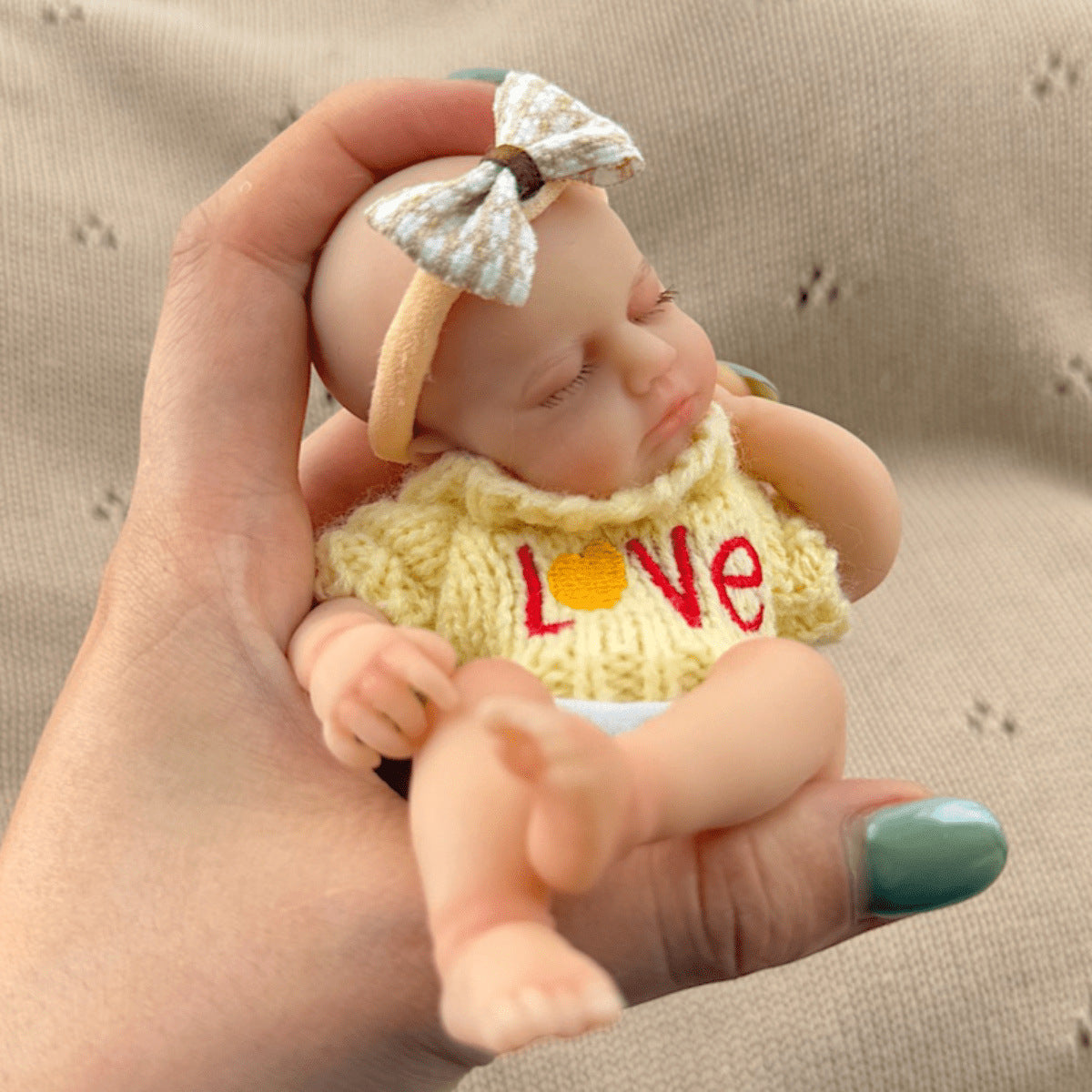 Bambola reborn mini Loulou in silicone 15 cm occhi chiusi estensibile con maglione giallo