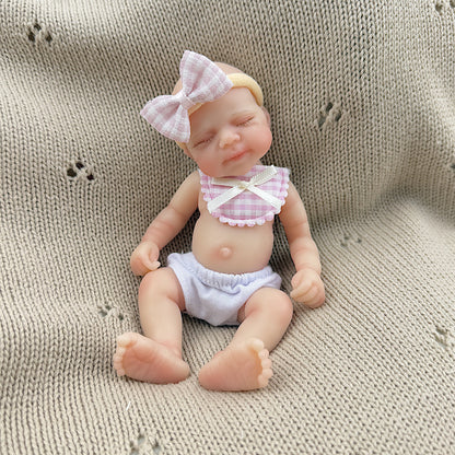 Bambola reborn Pascale in silicone da 15 cm con occhi chiusi e bavaglino a quadri rosa