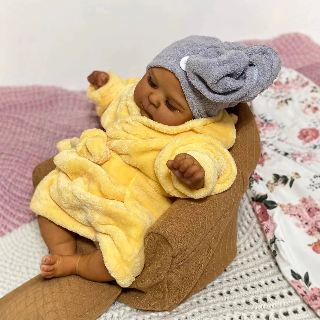 Bambola reborn realistica da 19 pollici con occhi chiusi e pelle scura Peaches in accappatoio giallo