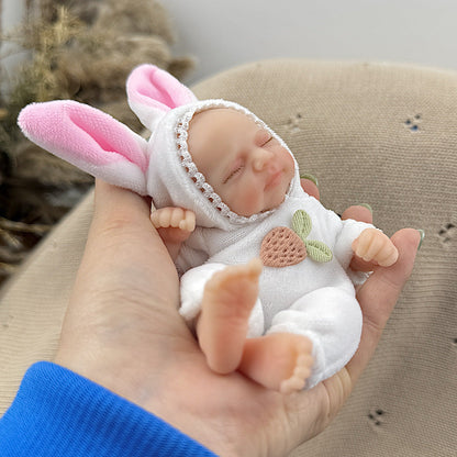 Bambola reborn Pascale Mini in silicone da 15 cm con occhi chiusi vestita da coniglietto bianco