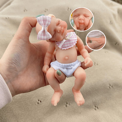 Bambola reborn Pascale in silicone da 15 cm con occhi chiusi e bavaglino a quadri rosa