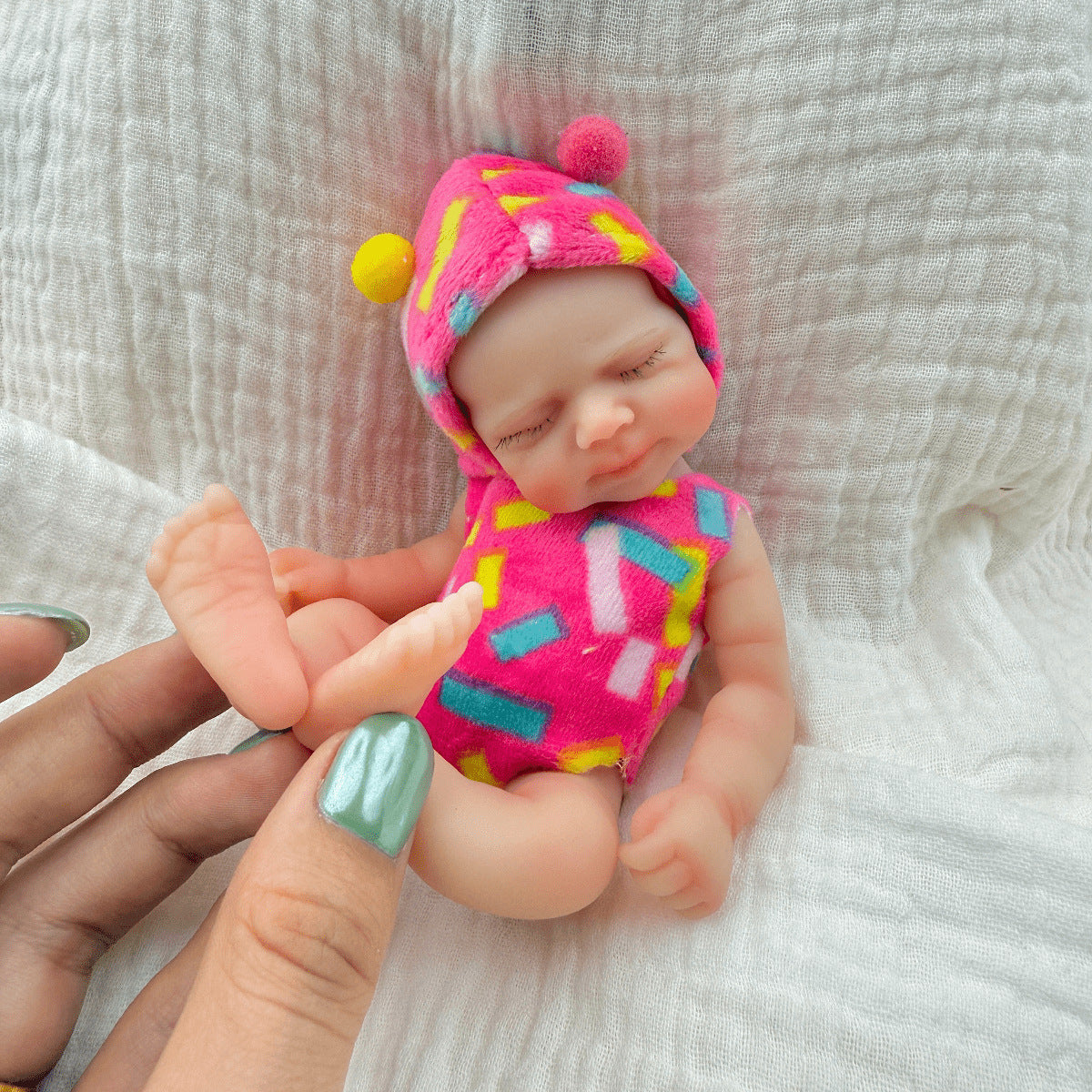 Bambola reborn Pascale Mini in silicone da 15 cm con occhi chiusi vestita con abiti rosa