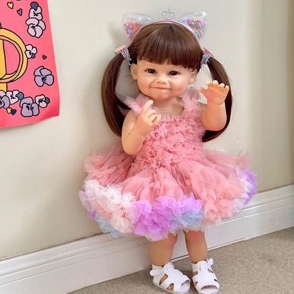 Bambola Reborn Raya da 55 cm con capelli lunghi e abito rosa