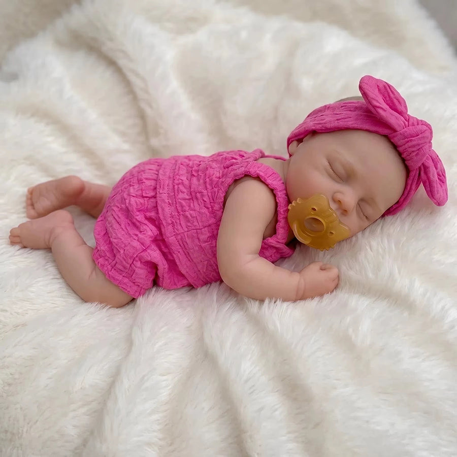 Bambola reborn Irys 30 cm realistica interamente in silicone con occhi chiusi vestita con abiti rosa