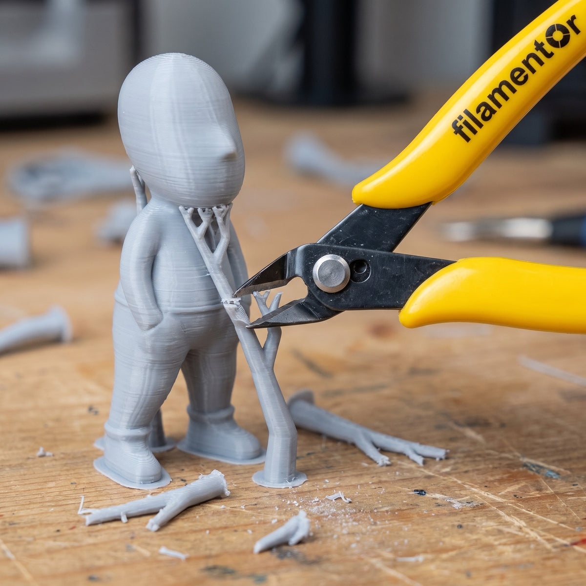 Filamentor zijkniptang verwijdert supports van een grijze 3D-print